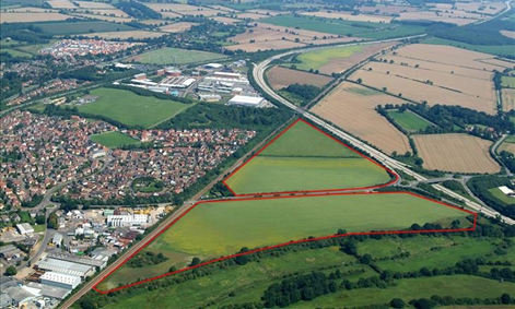 Oblique aerial photo of site showing area of farmland outlined in red