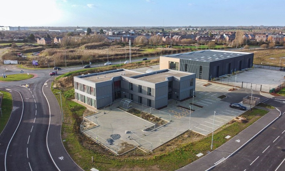Oblique aerial photo of site showing large industrial and office buildings