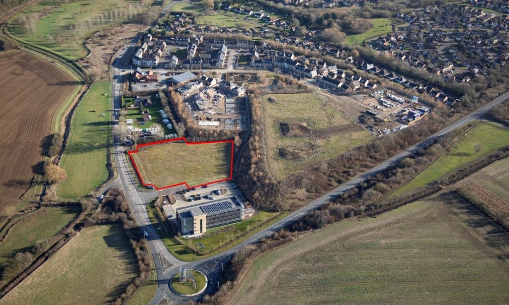 Aerial photo of site with red line depicting outer boundary of land