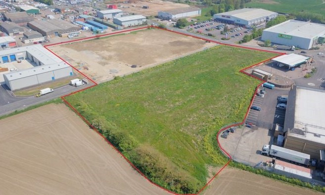 Aerial photo of site with red line depicting outer boundary of land